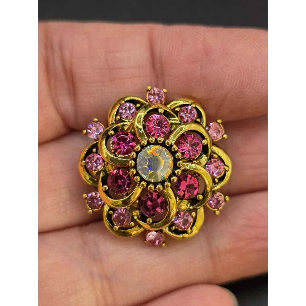 gold-toned floral brooch featuring pink and clear rhinestones